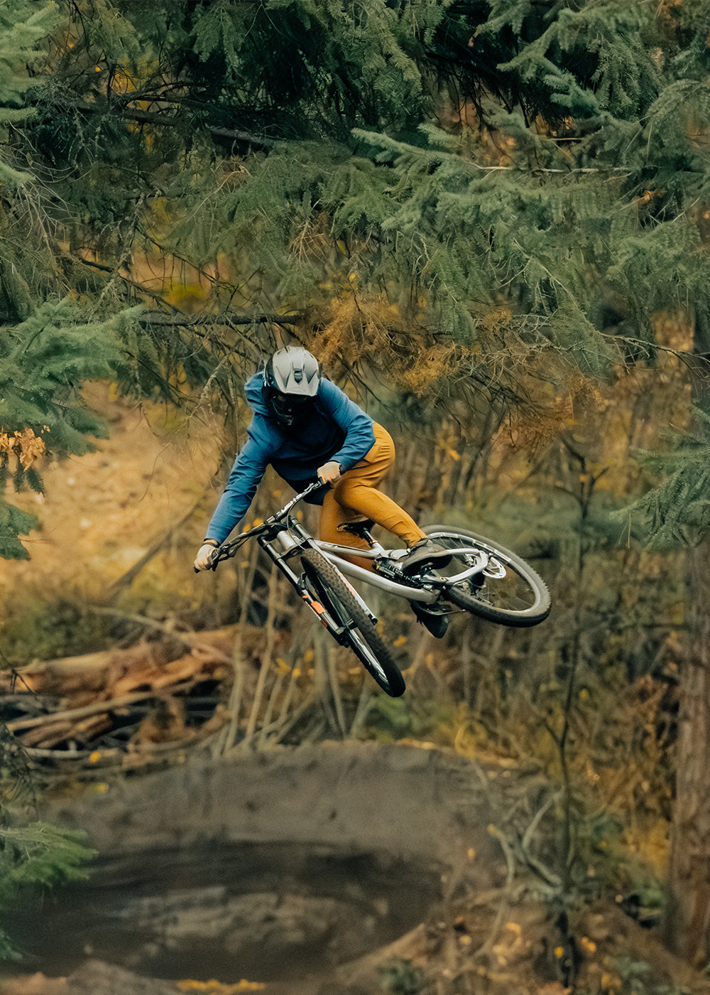 Mountain Biker goes off a big jump while wearing the Outdoor Research Freewheel collection.