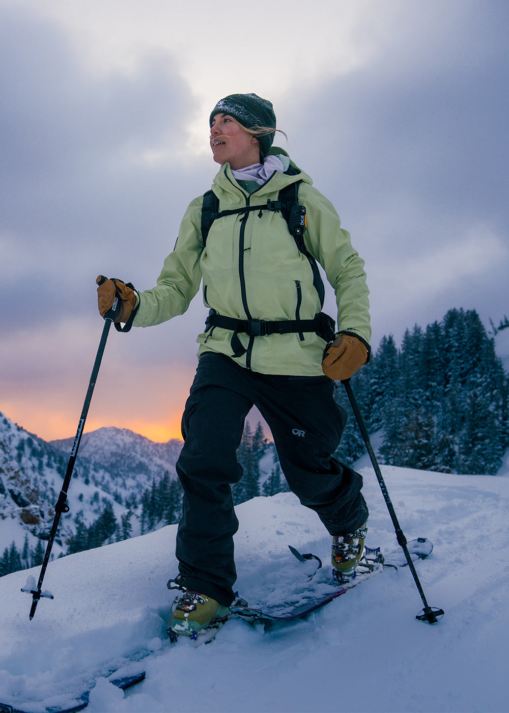 Outdoor Research ski athlete Sophia Rouches wears the Skytour AscentShell Jacket in Cool Matcha while out on a tour at dusk.