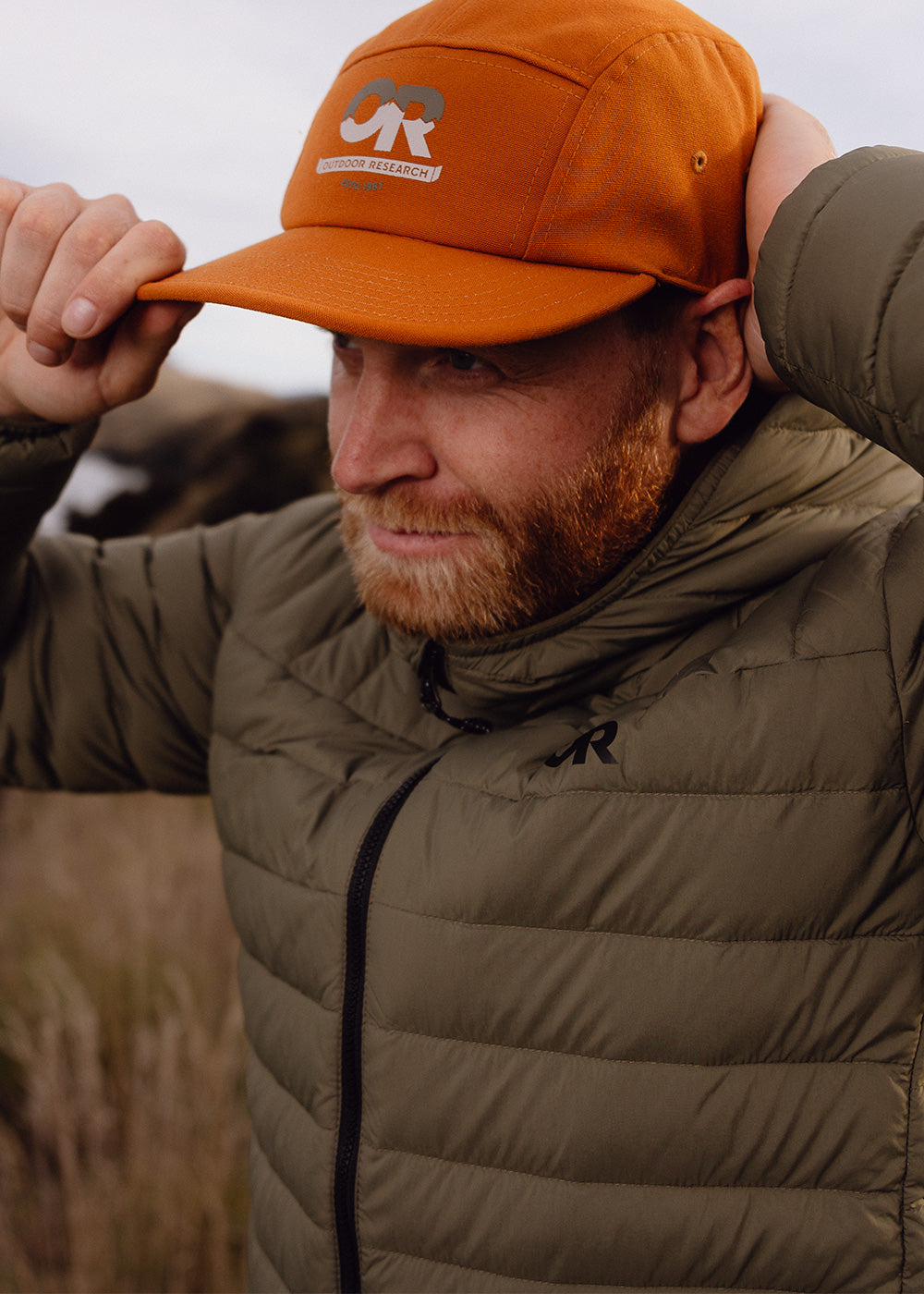 A man wears the Transcendent Down Hoodie while out on a hike.