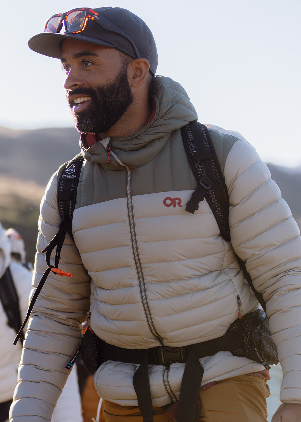 A man sets out on a hike wearing an Outdoor Research Transcendent Down Hoodie.