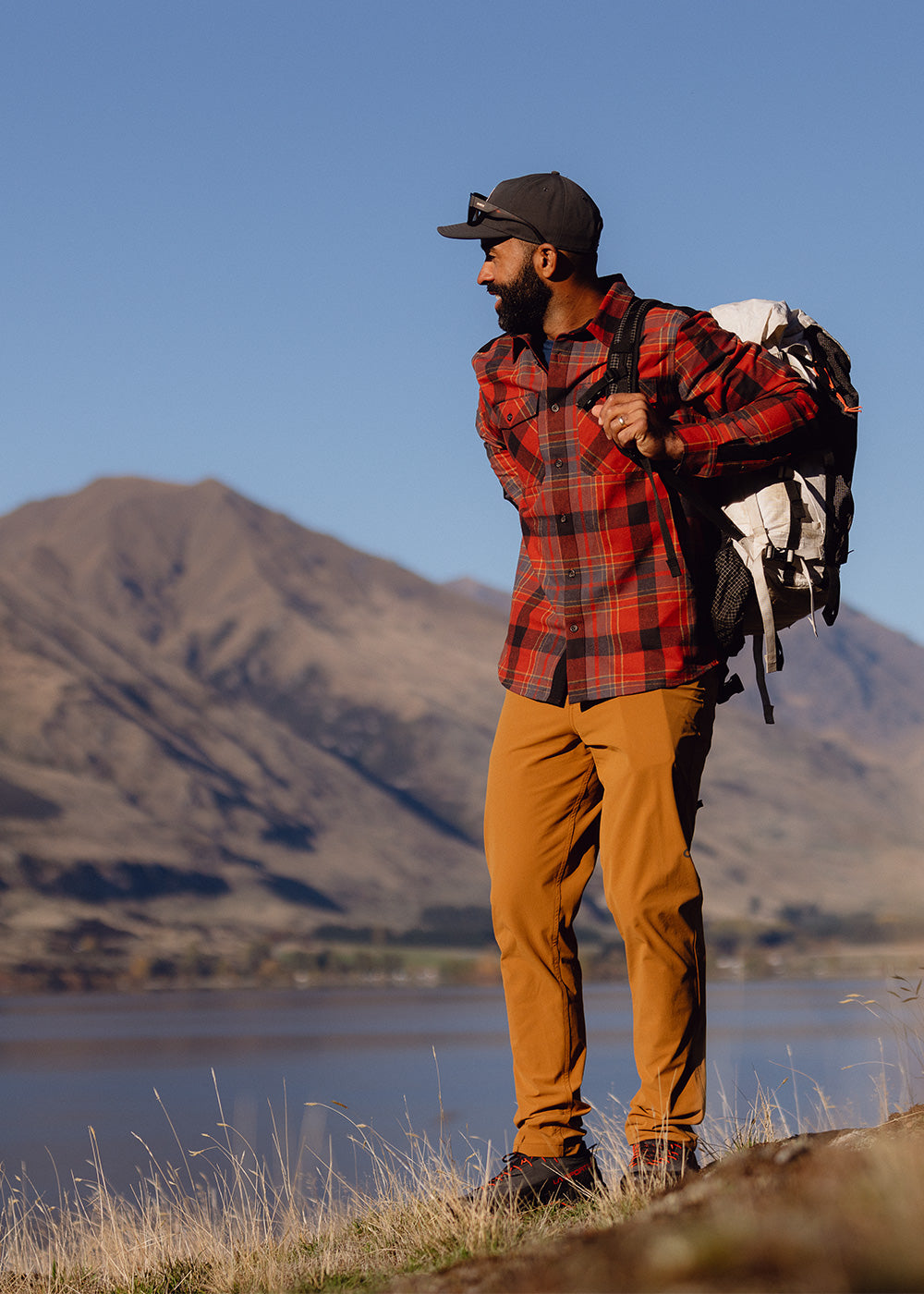 A man wears the Wallingford Flannel Shirt Jacket in Jupiter Plaid while out on a hike.