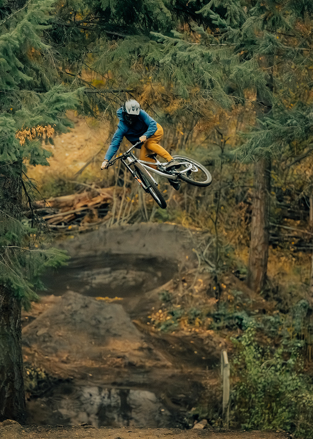 Mountain Biker goes off a big jump while wearing the Outdoor Research Freewheel collection.