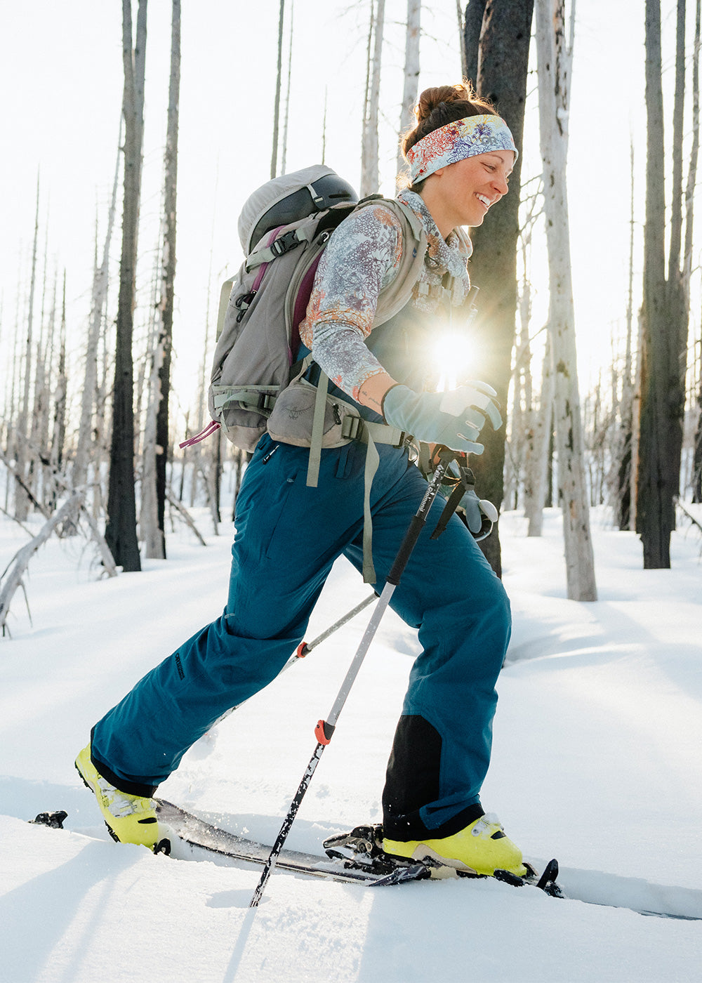 Two friends on a ski tour traverse through the trees wearing Outdoor Research Sportswear and Outerwear. 