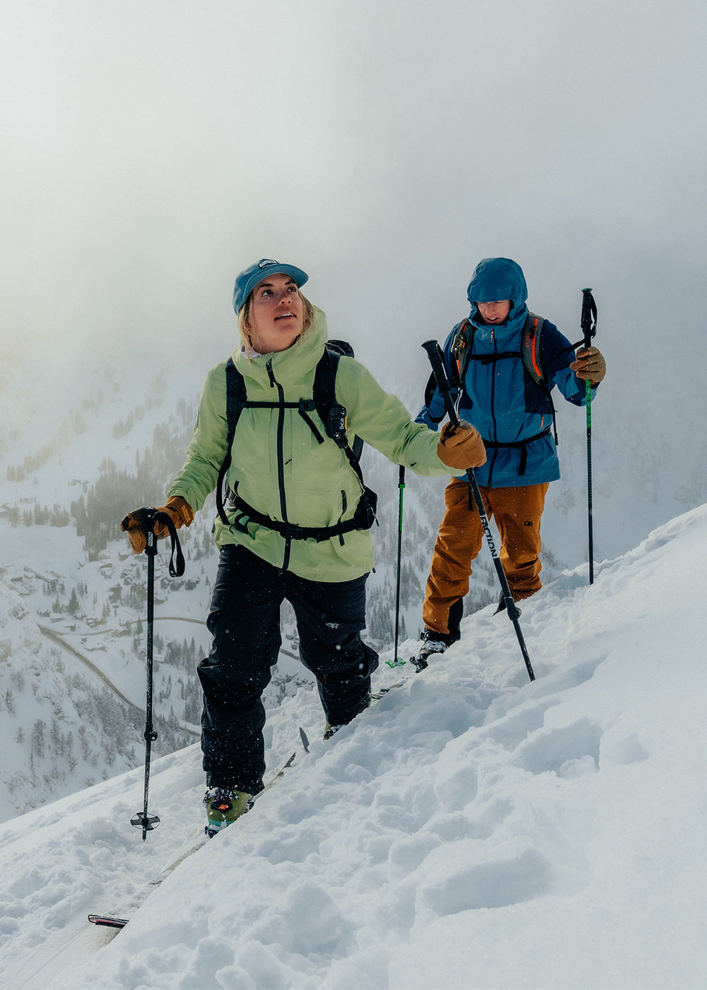 Two friends traverse through the snow on skies wearing Outdoor Research Skytour AscentShell Jackets.