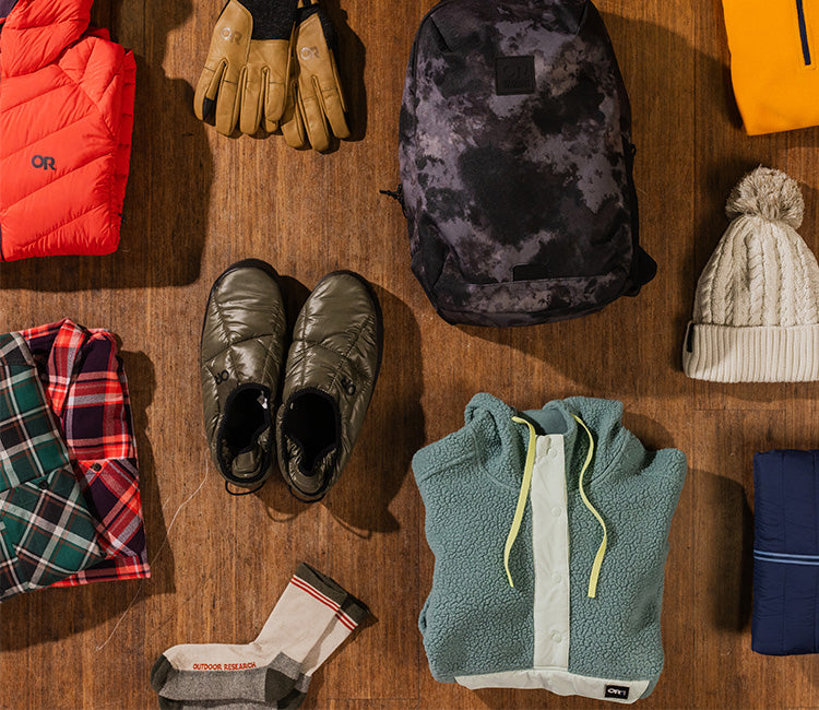 Overhead view of an Outdoor Research backpack, beanies, booties, jackets, and more.