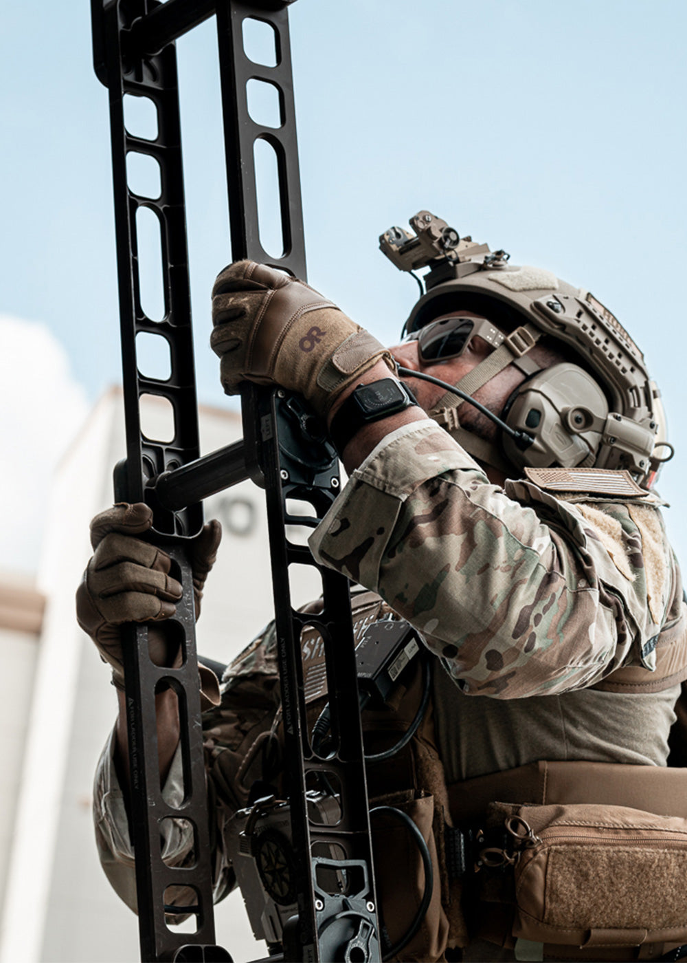 A man climbs a ladder wearing tactical gear.