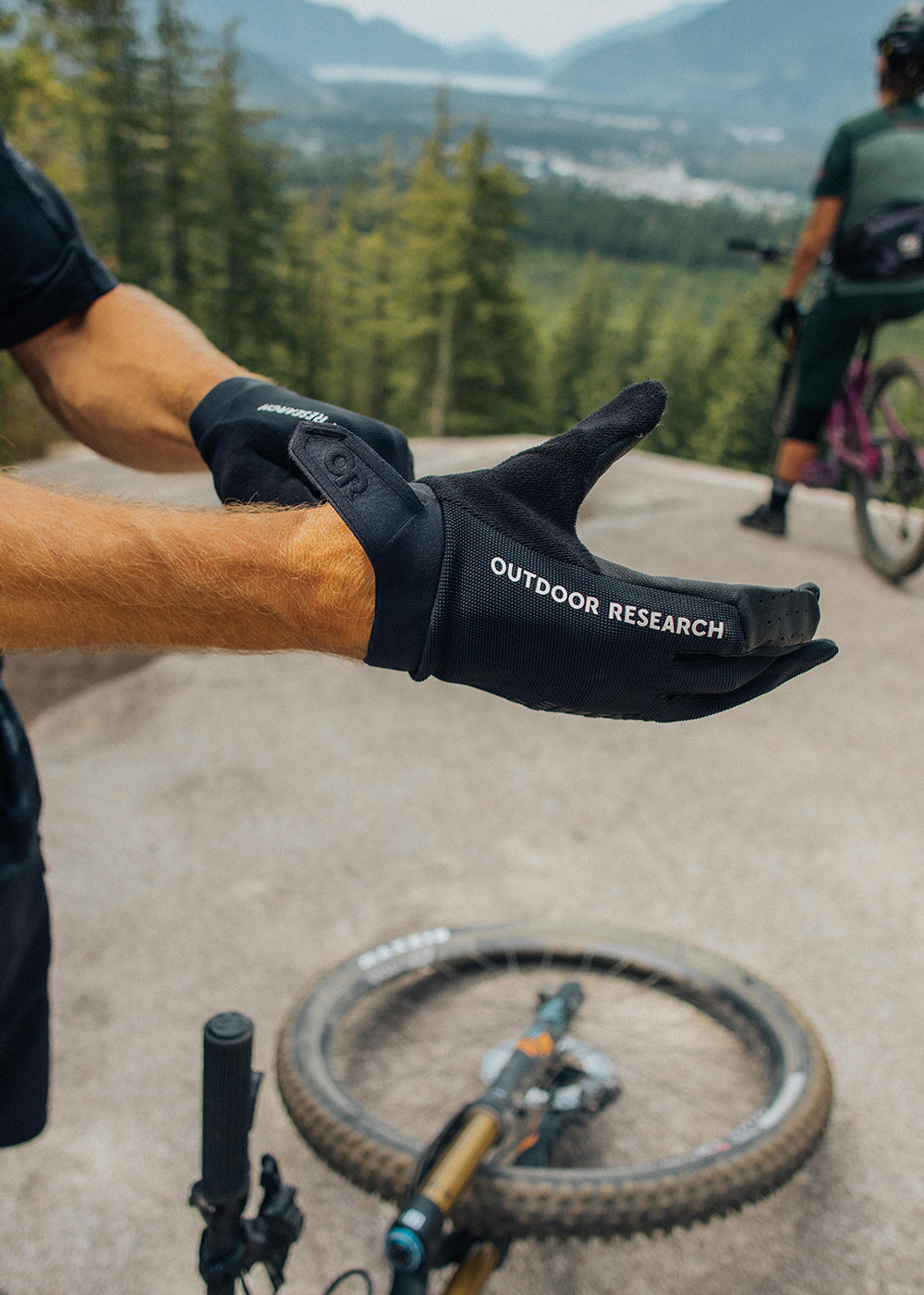 A mountain biker pulls on the Freewheel Leather Palm Bike Gloves.